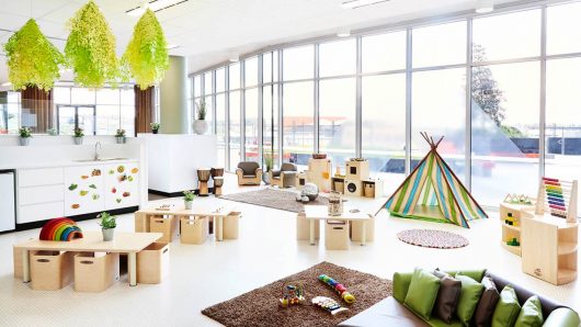 Bright and spacious indoor play area at Guardian Childcare Springfield, Queensland, featuring distinct zones for dramatic play, construction, music, and quiet reading, all bathed in natural light.
