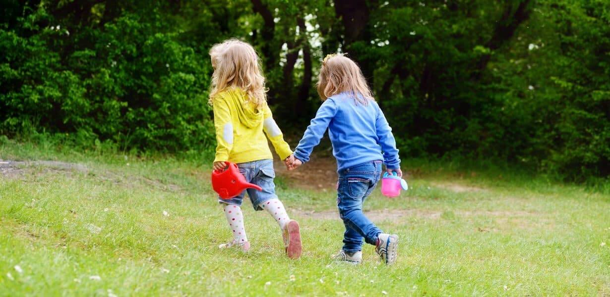 two girls holding hands in park