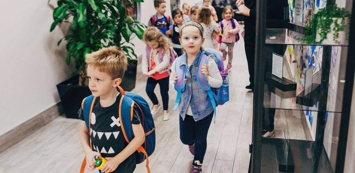 Children carrying backpacks in centre