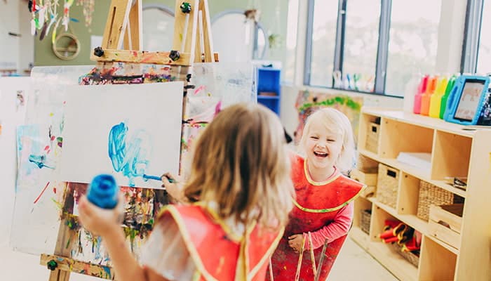 Two children painting and laughing