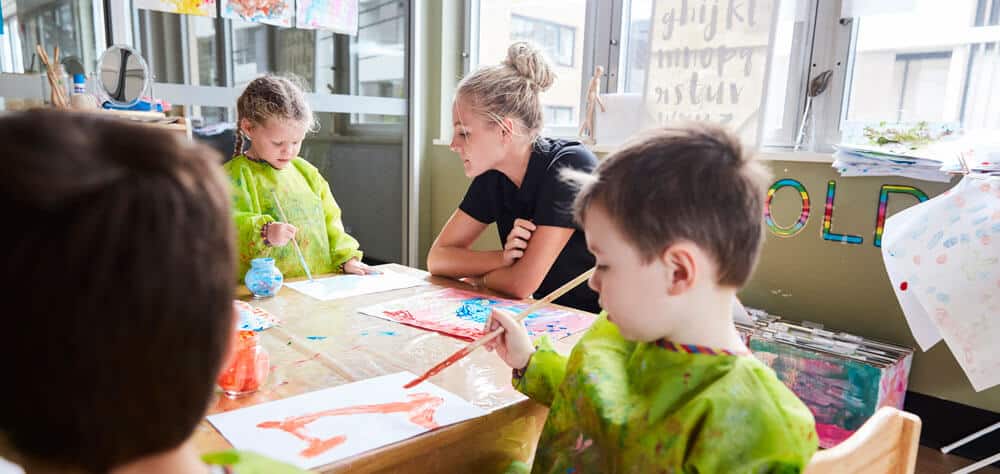 Educator with three children doing art and painting at NAIDOC Week