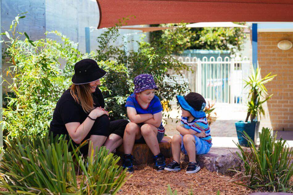 Educator outside with discussing garden, sparking children's curiosity