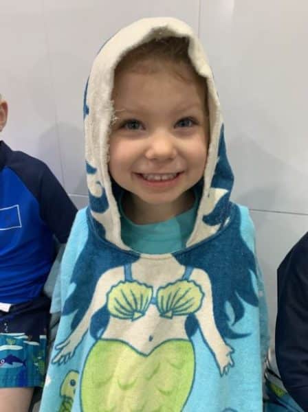 young child in mermaid towel at swimming lessons