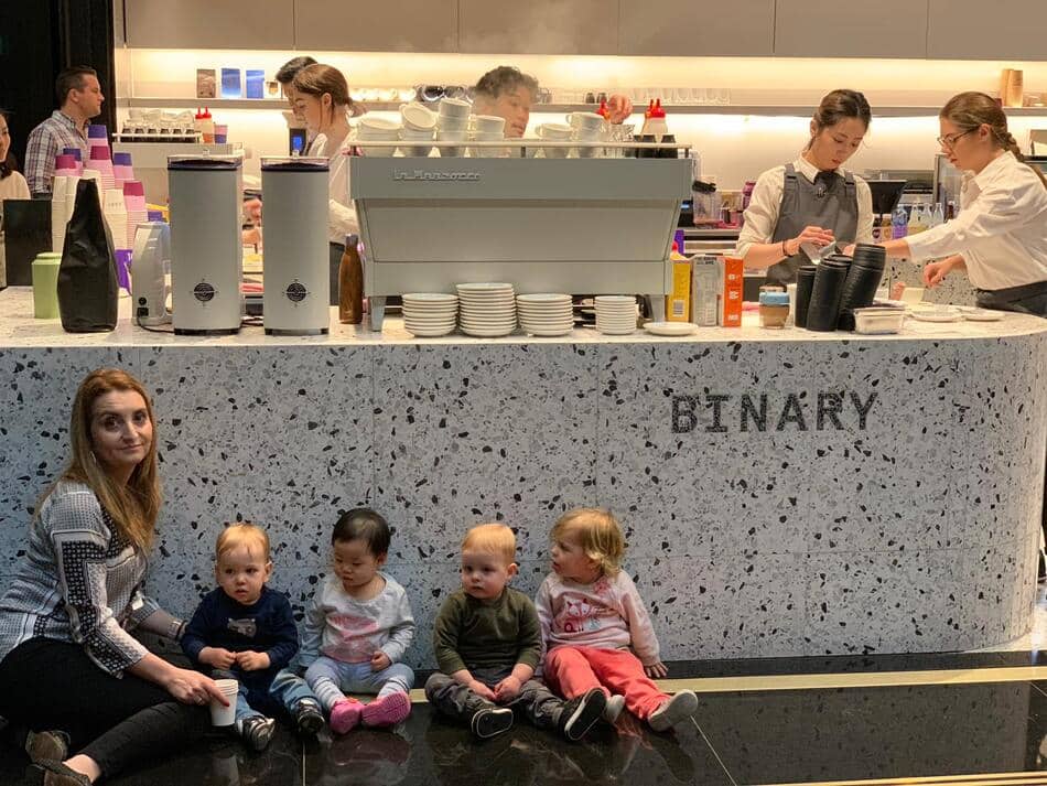 Educator and 4 children in front of Binary Cafe