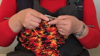 educator knitting for yarn bombing project