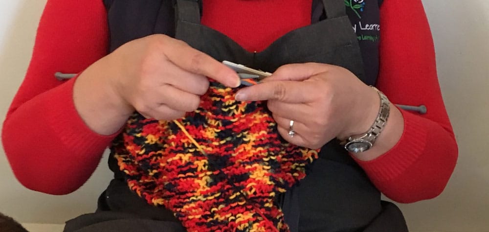 educator knitting for yarn bombing project