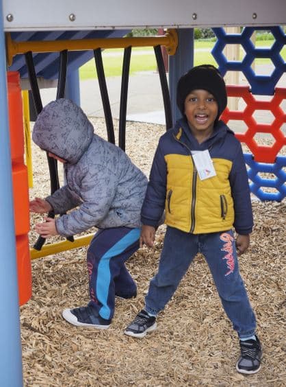 two young boys playing on playground at excursion program