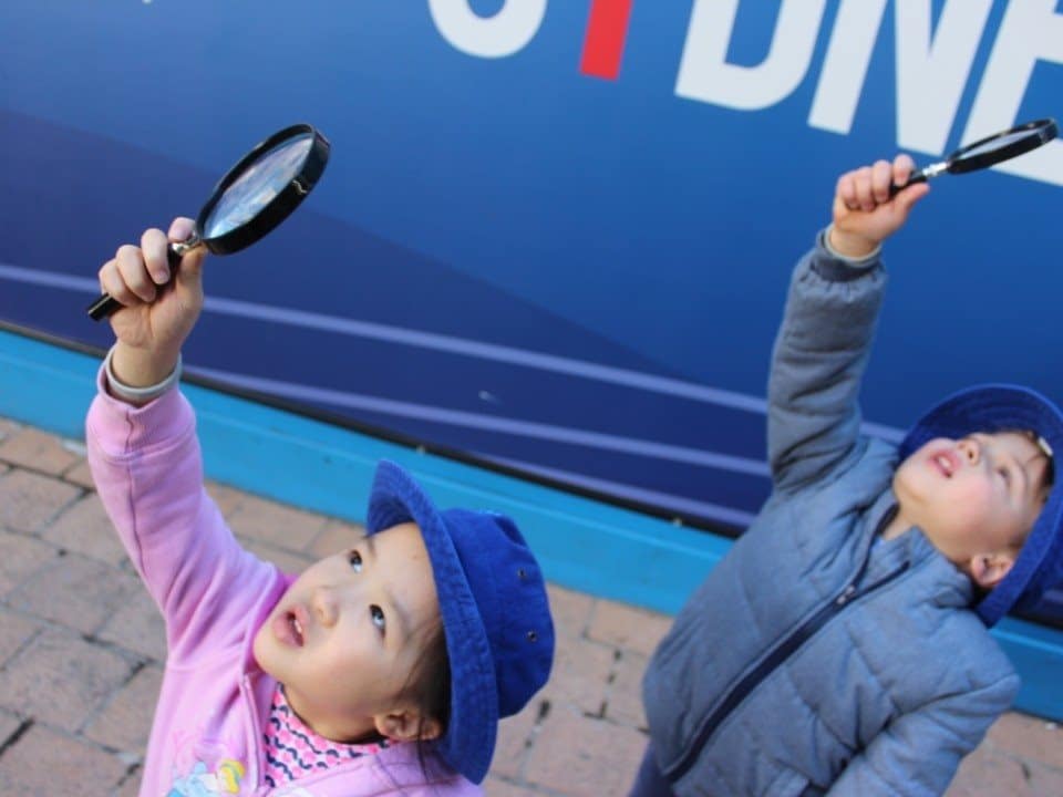children using magnifying glasses on excursion in Sydney
