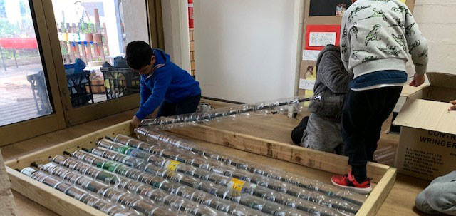 children building greenhouse out of plastic bottles