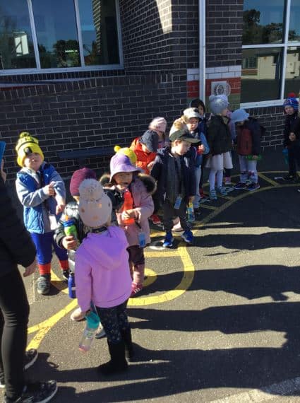 children lining up outside building for an excursion