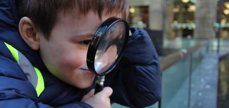child using a magnifying glass on excursion in Sydney
