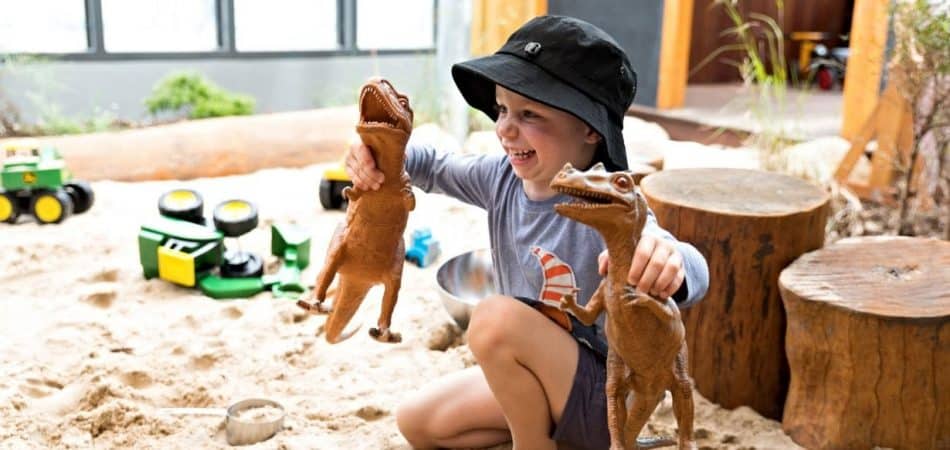child playing with dinosaurs outside at Guardian Everton Hills