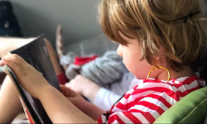 child reading book and dressed as a pirate for book week
