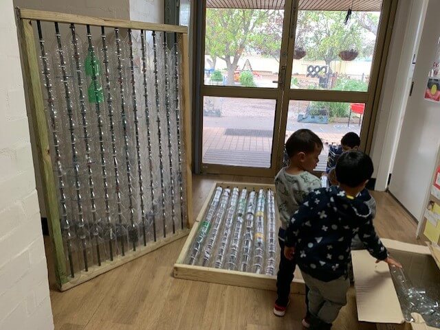 children building greenhouse out of plastic bottles