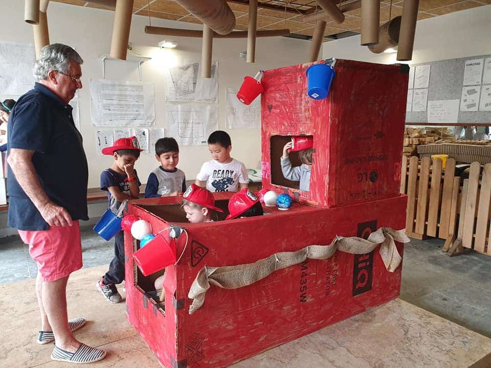 children and teacher building fire truck