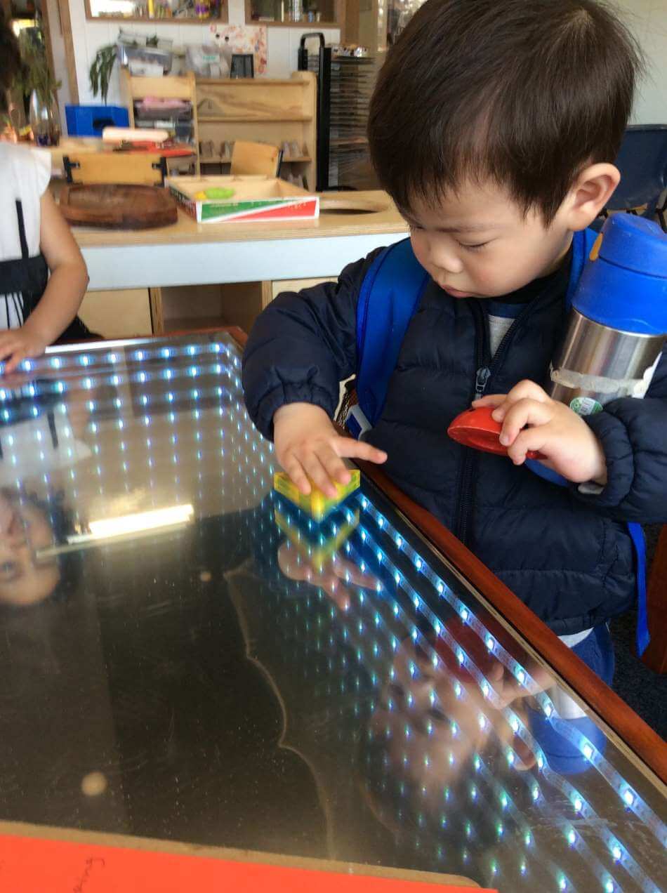 child playing with shapes on infinity table