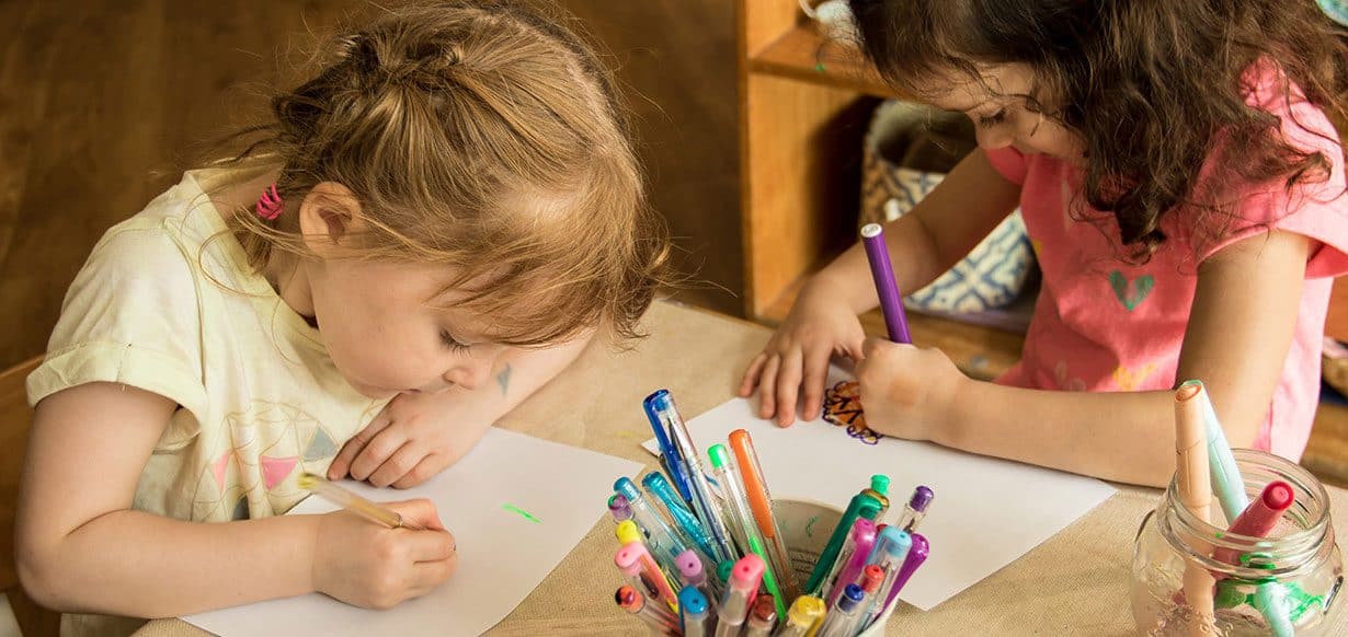 Two children colouring in with pens