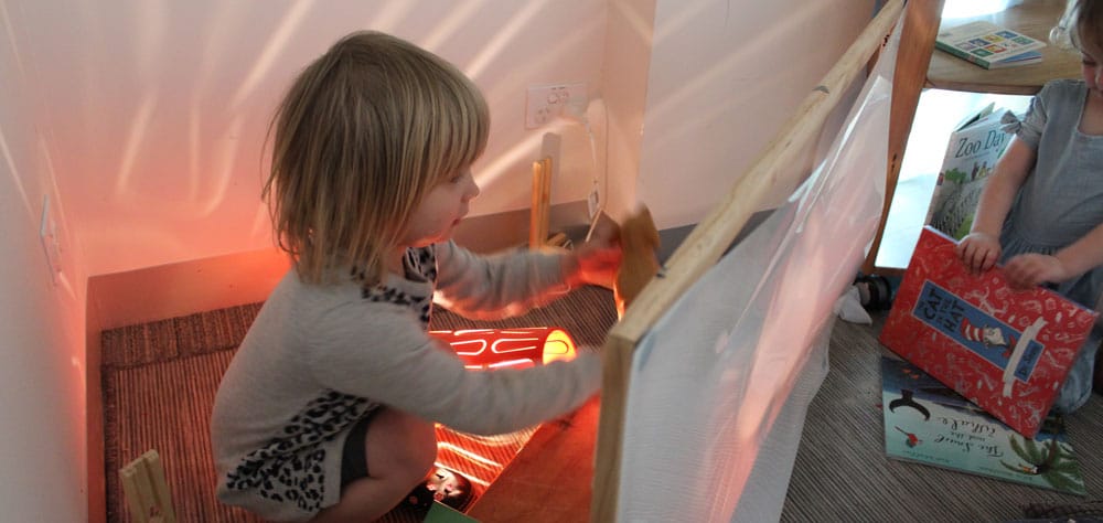 child playing with shadows and light in storytelling space