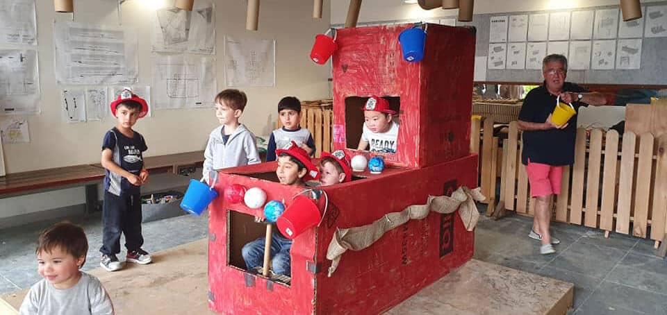 children build fire truck out of recycled materials at River Garden