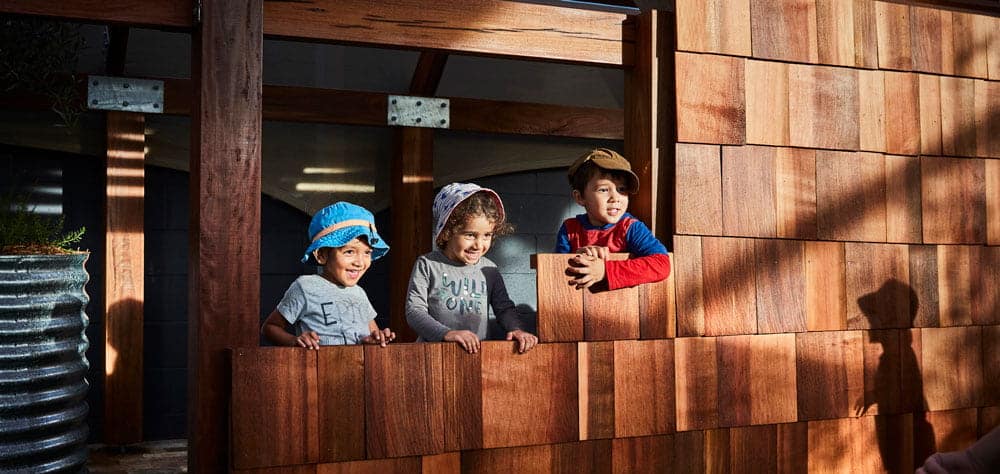 children playing in wooden cubby house practicing resilience