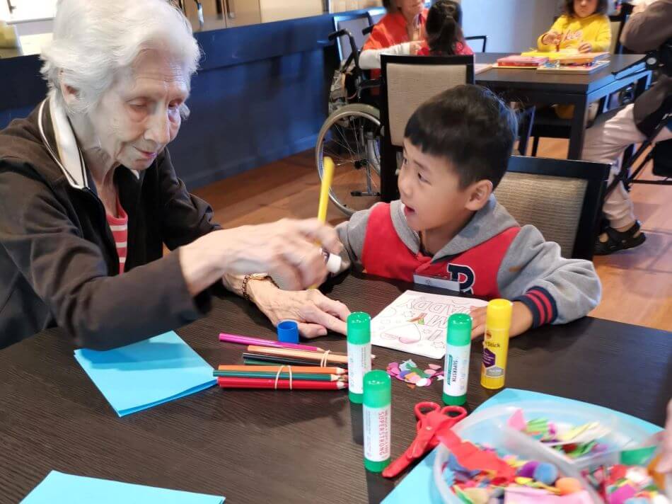 child and eldery woman drawing at playgroup