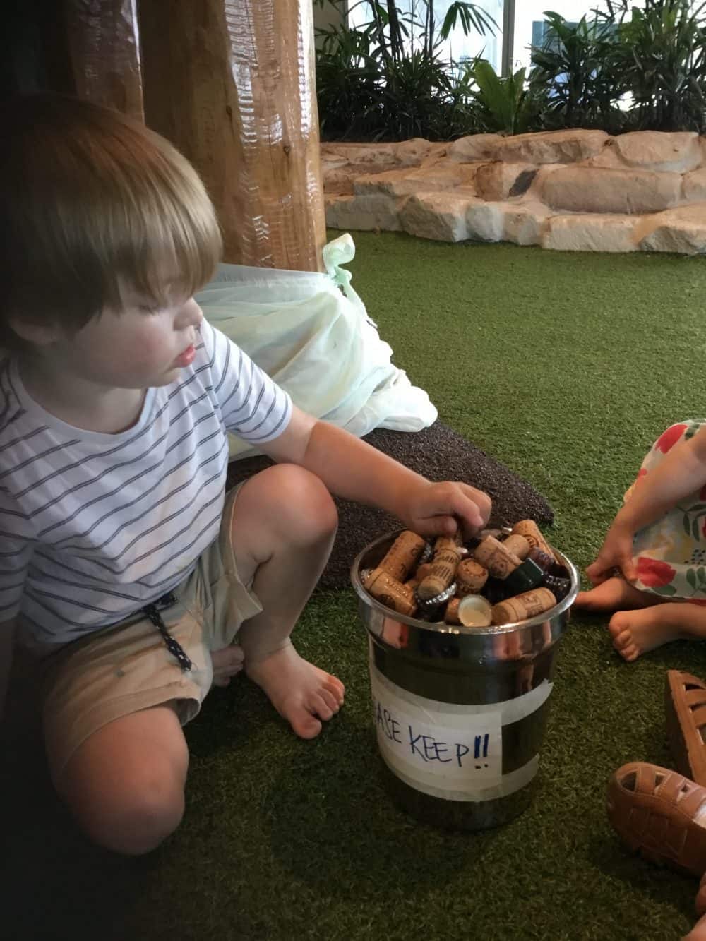 children holding recycled bottle corks