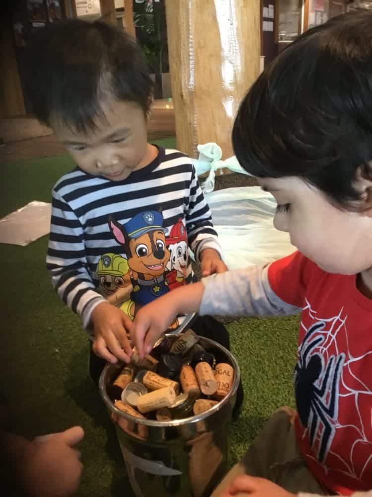 children at Guardian Queen Street holding recycled corks and bottle caps