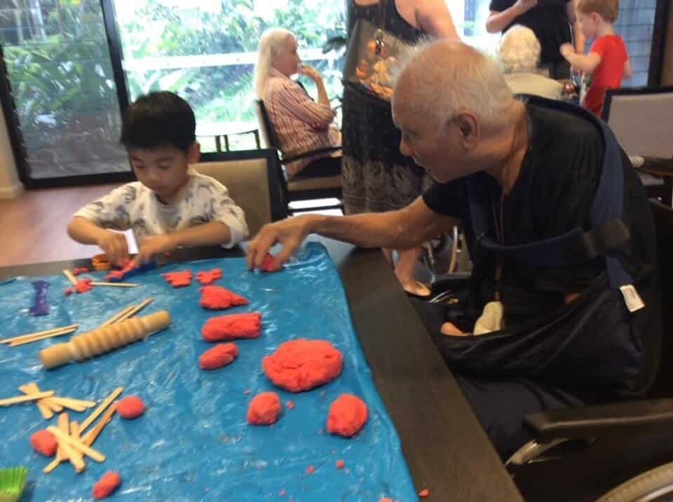 child and eldery man creating with playdough at playgroup