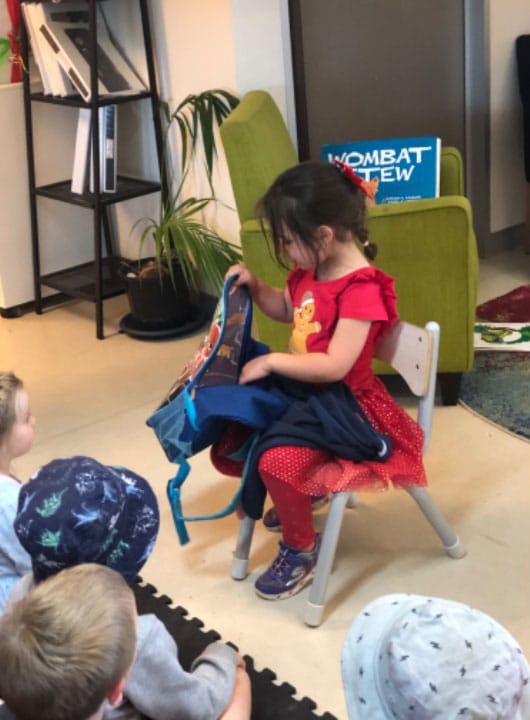 Ellie showing preschool children her Big School backpack