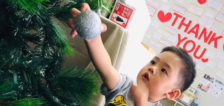 child decorating Christmas tree