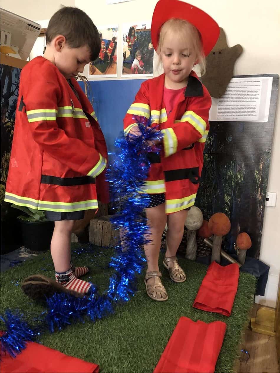 children using role play to dress up as firefighters