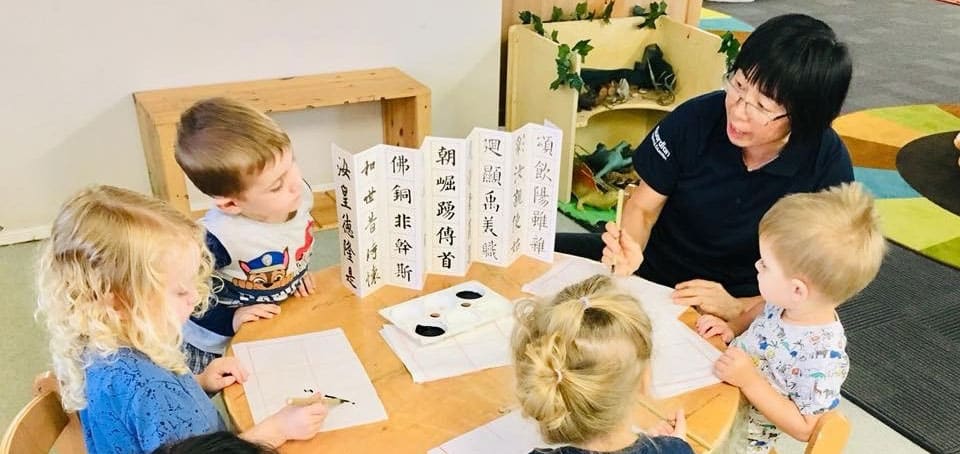 children learning about traditional calligraphy for Chinese New Year