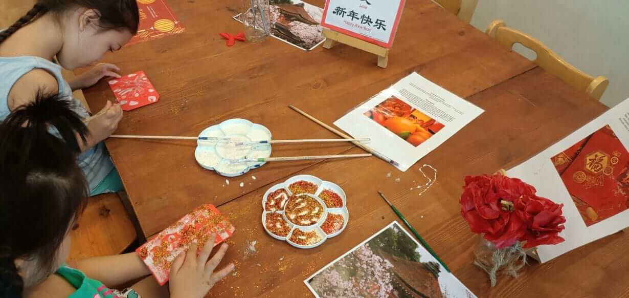 Children decorating red envelopes during Chinese New Year celebration