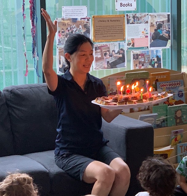 Helen holding cake to celebrate 10 years at centre