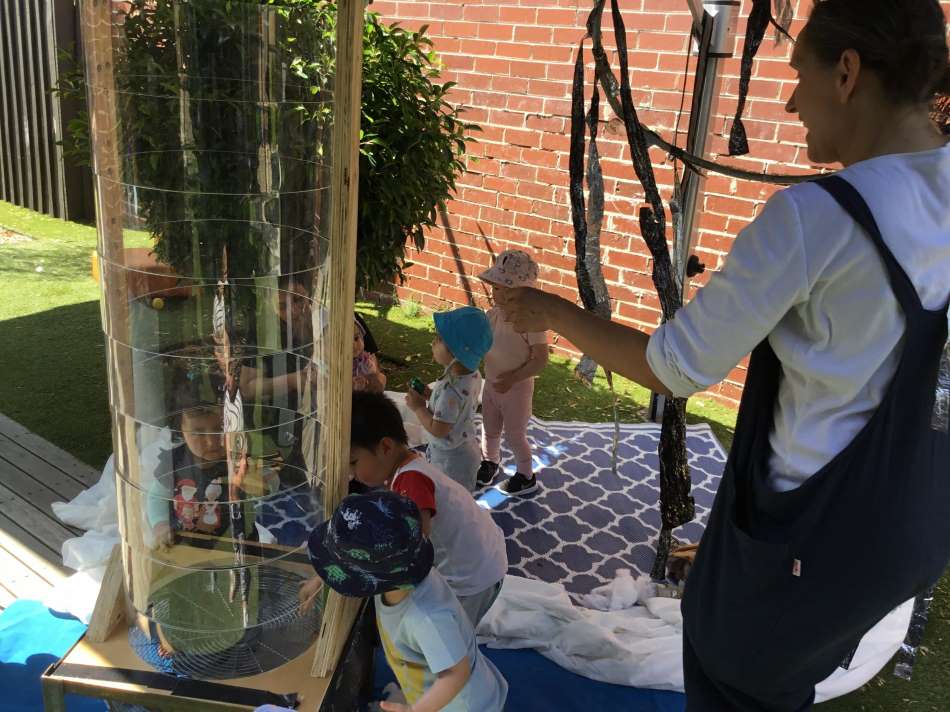 toddlers testing if cotton wool can fly in wind tunnel during Summer Rain program