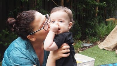 mother kissing baby at nursery morning tea