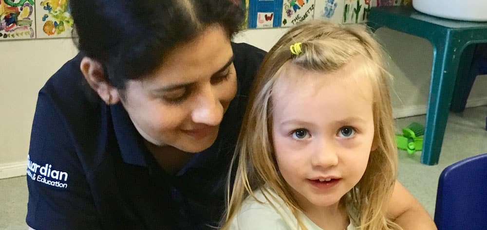 Educator and child sitting together during tea time