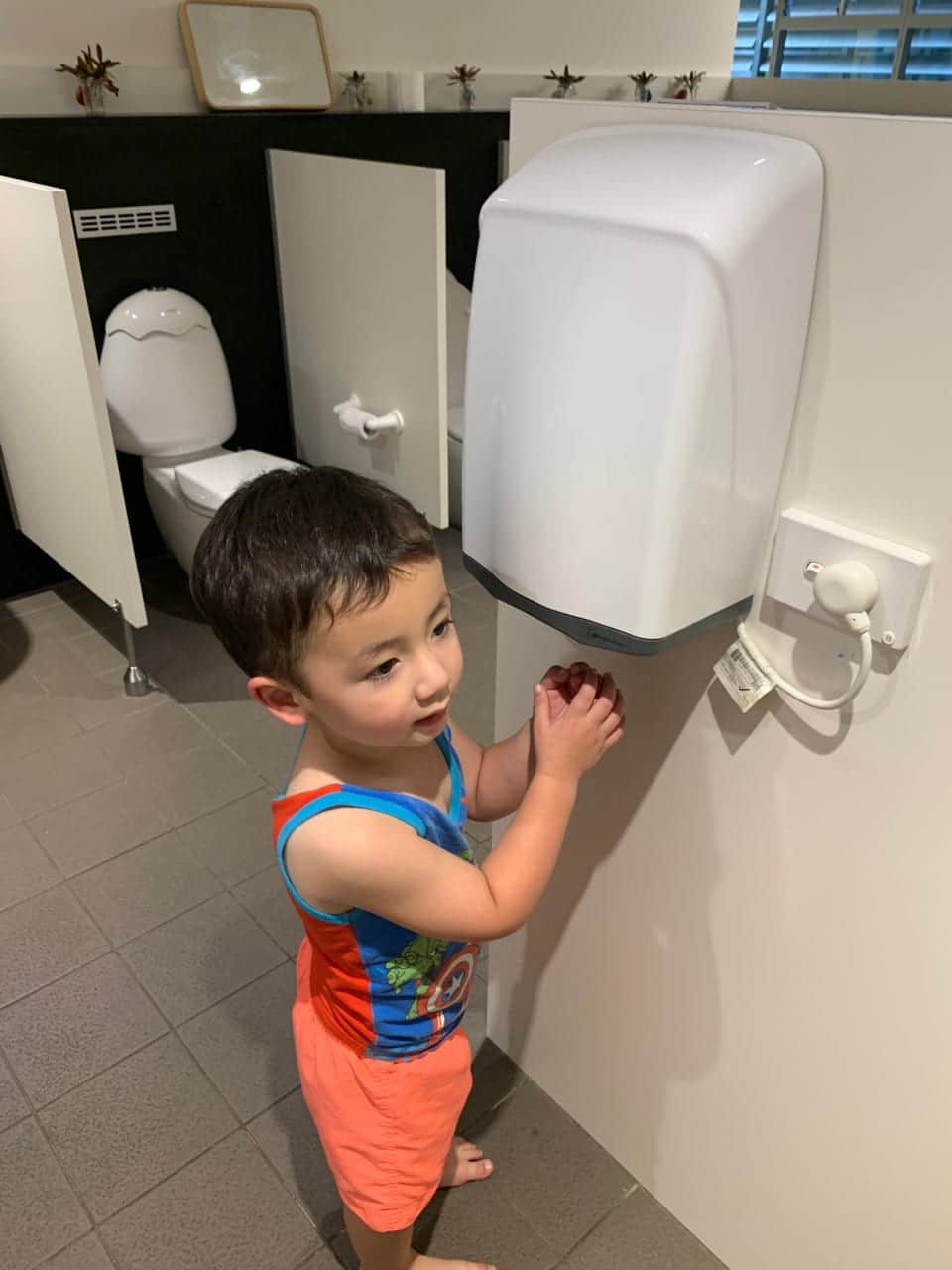 child using hand dryer at childcare centre