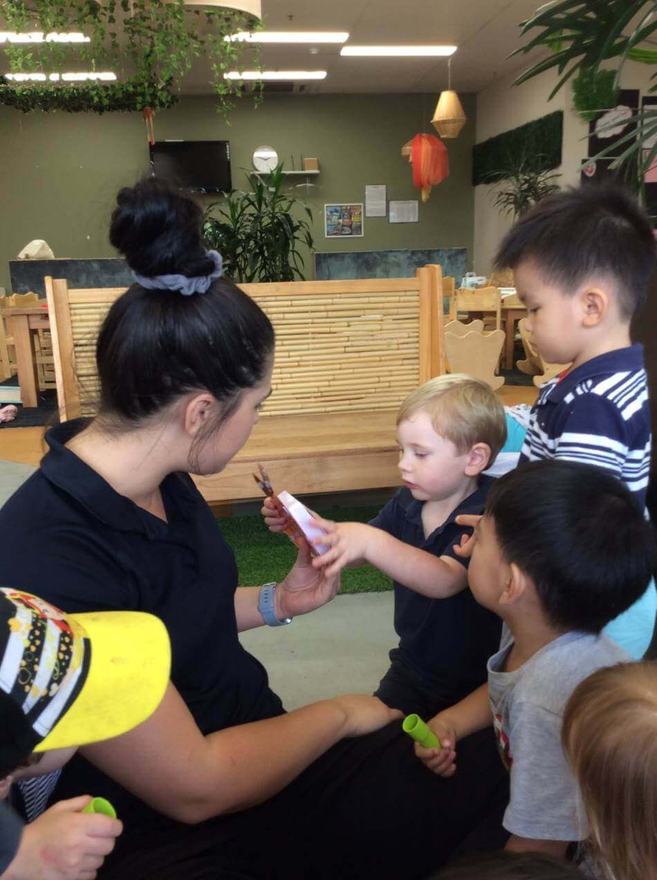 children talking to Educator about families and magic hug button