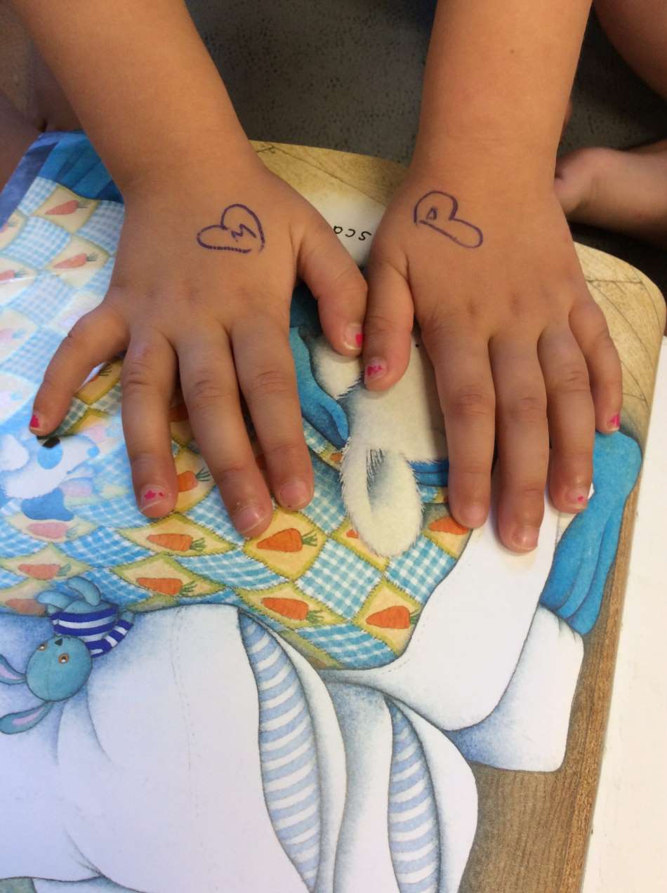 child with love hearts and initials for parents drawn on her hands @ Guardian Marrickville