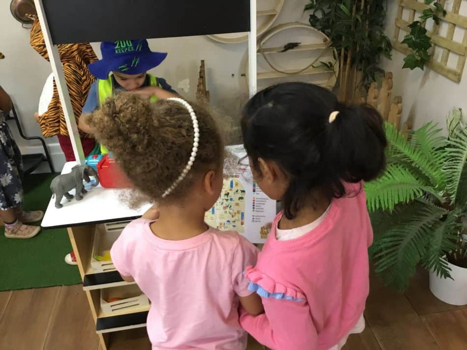 children reading zoo brochure in sociodramatic play space