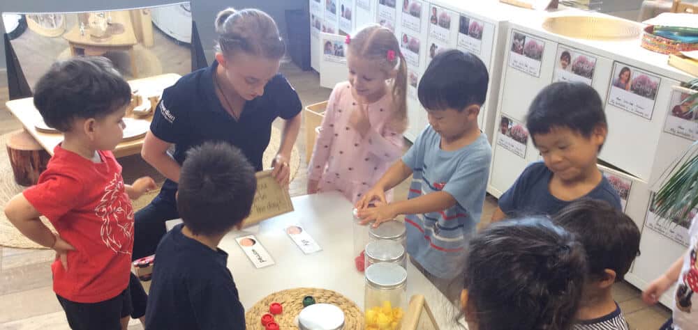 children gathered around a table learning how to use emotion cards