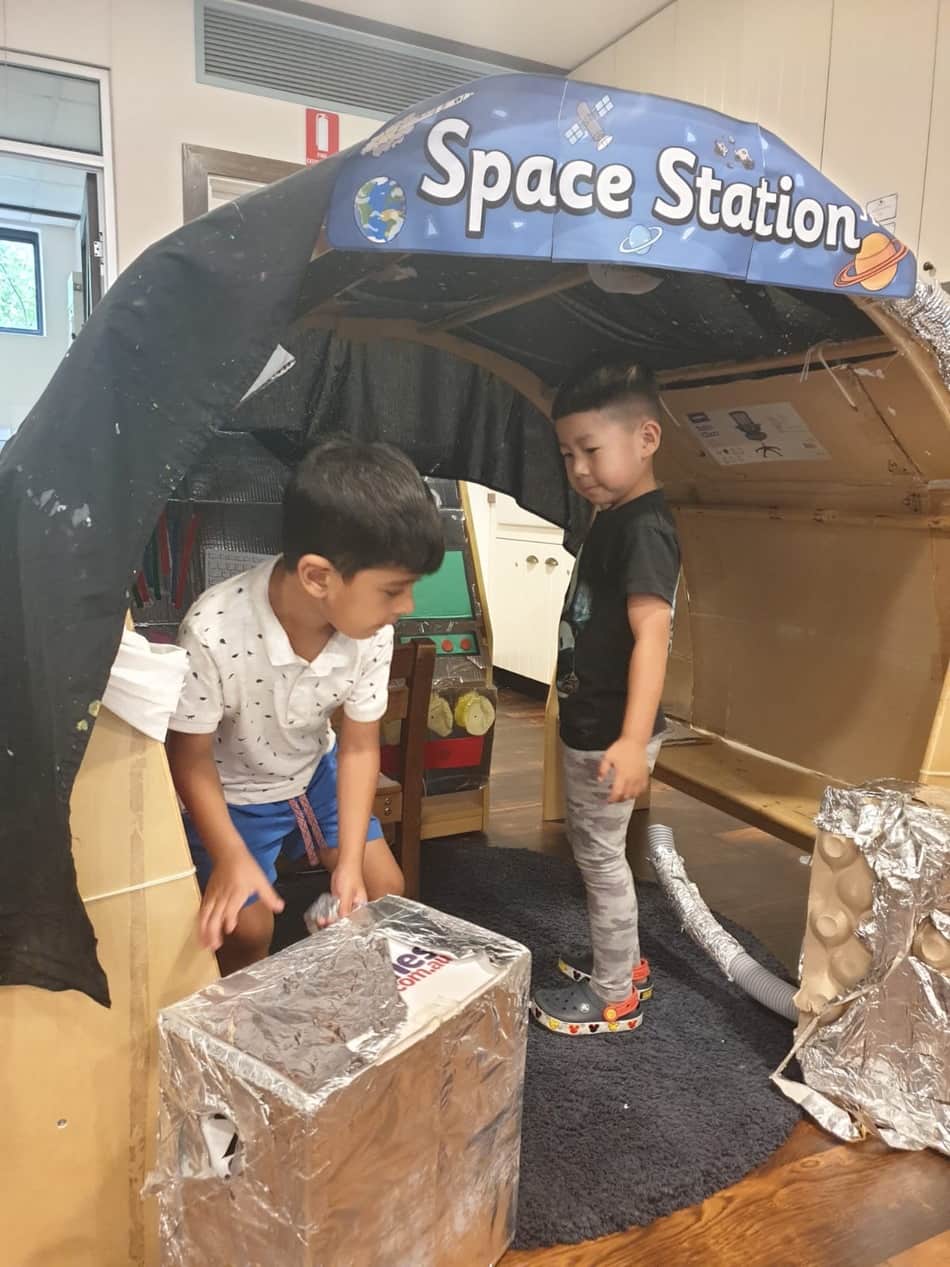 two children playing in space station