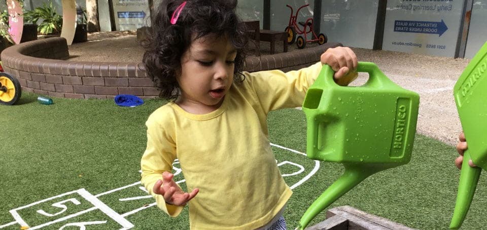child holding water can and planting native trees for bushfire appeal