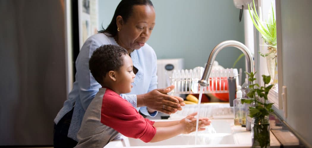 child and mother washing their hands, hand sanitiser on bench