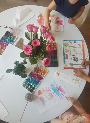 children using flowers they received for delivering care packages in water colour experience