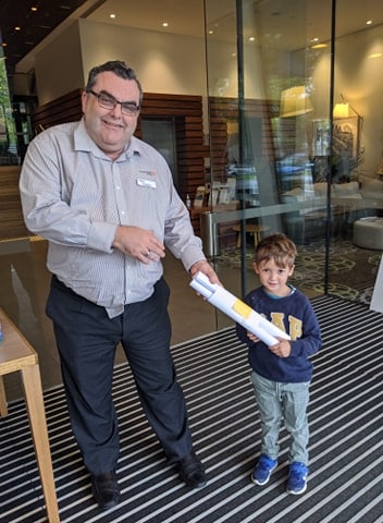 child delivering drawings to local business owner