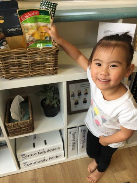 child adding soup to centre share basket