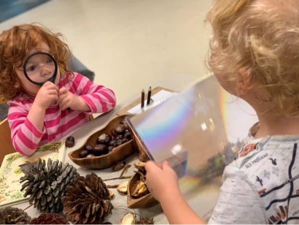 child pressing magnifying glass up to her face