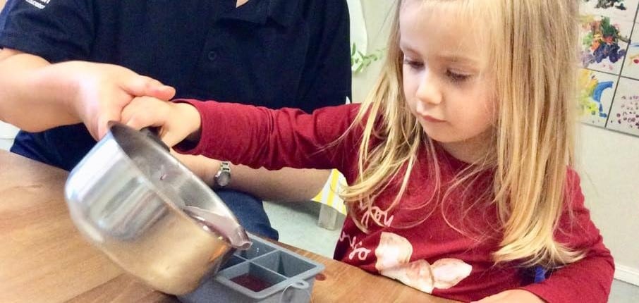 Child pouring candle wax into moulds for Earth Hour celebrations